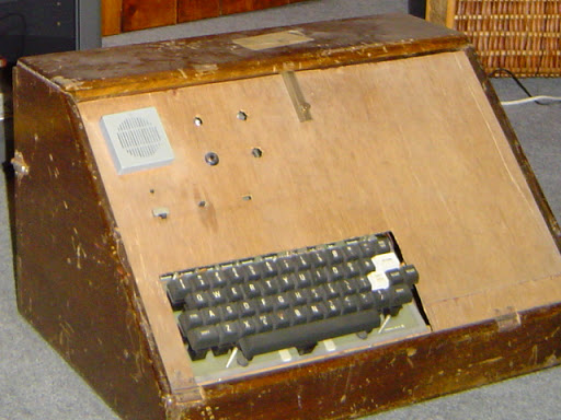 Large and scruffy wooden box with speaker and keyboard visible