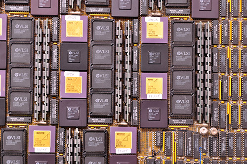 Closeup of circuit board with some large chips on it, some with gold tops