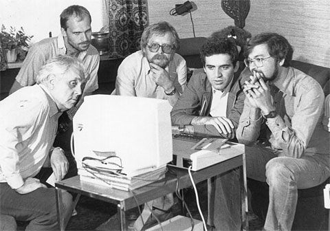 Kasparov and journalists in deep thought in front of a BBC Micro