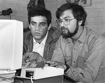 Kasparov and another man in discussion over a BBC Micro